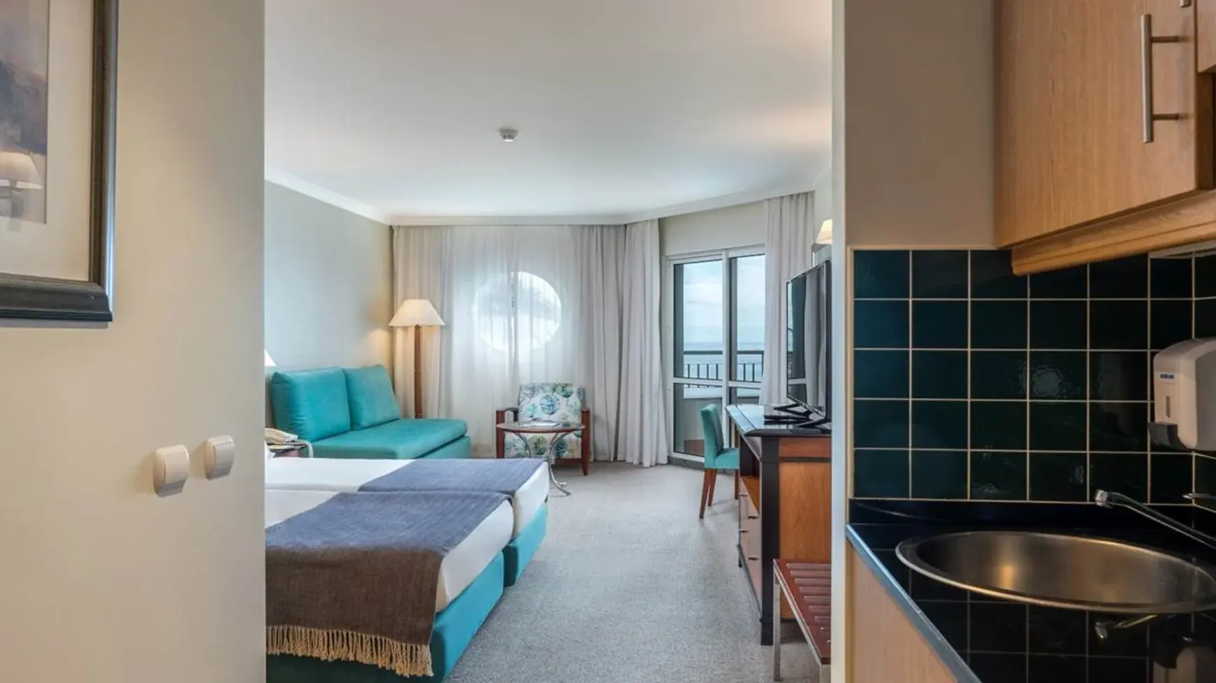 Family room with a double bed or 2 single beds, a divan sofa and a balcony. The bathroom has a bathtub and a hairdryer. Room with maximum capacity for 2 adults + 2 children or 3 adults (extra bed). Area: 39m²